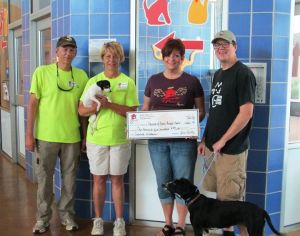 Laurie Loew gives Friends of Austin Animal Center donation.